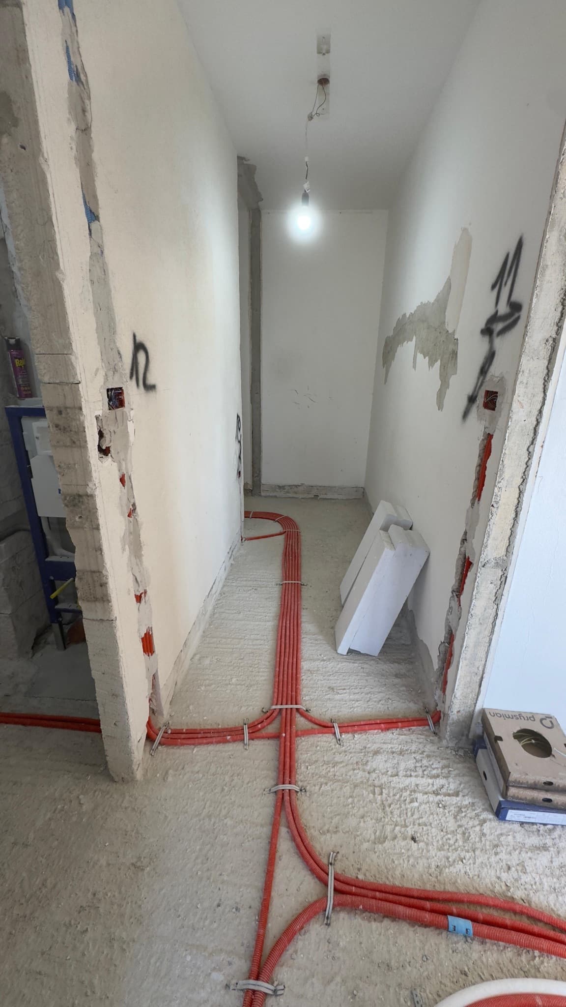 Instalacijske cijevi položene po podu hodnika tijekom grubih radova.