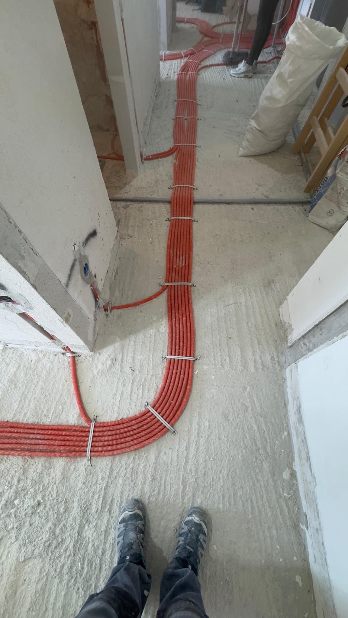 Snop instalacijskih cijevi učvršćen obujmicama uz prolaz između prostorija.