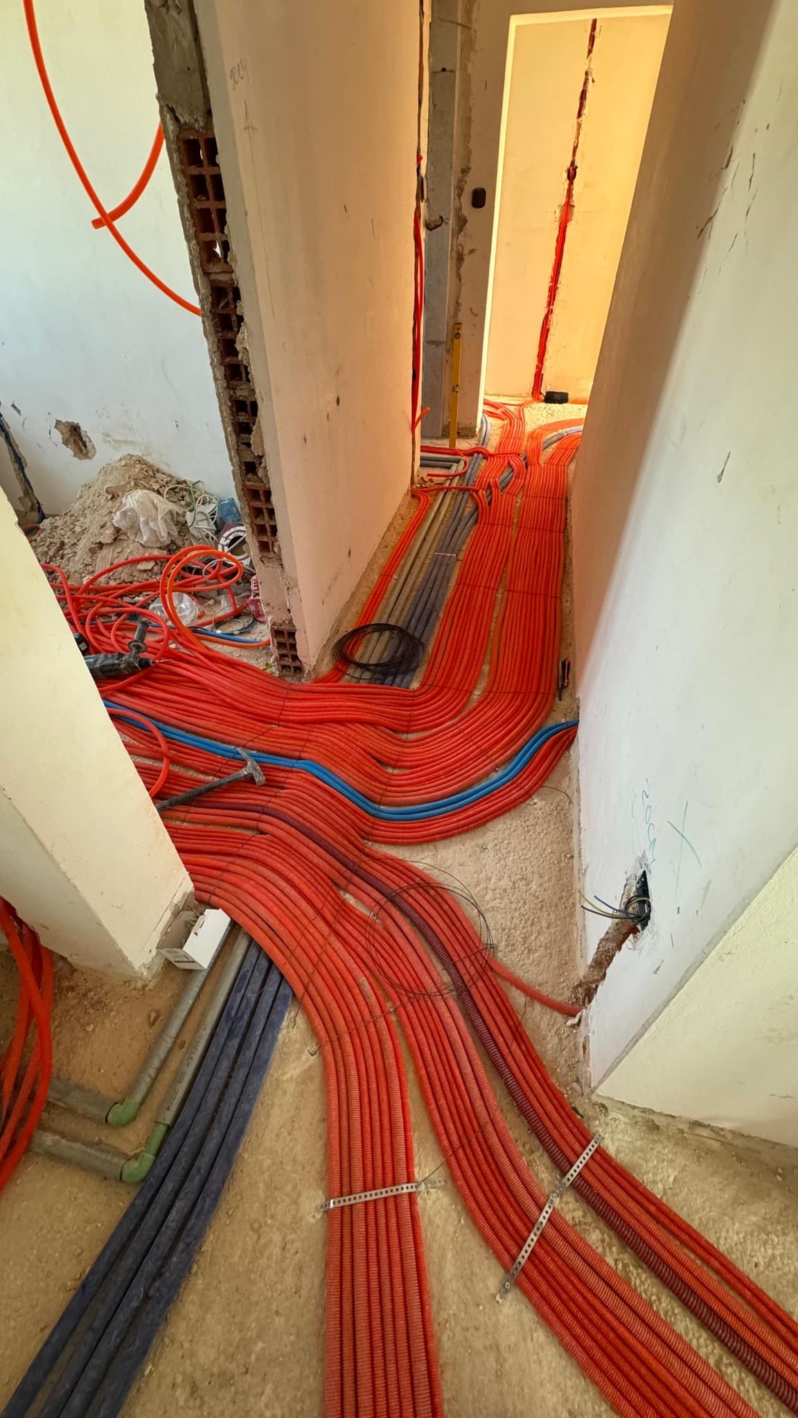 Gusti snop instalacijskih cijevi koji vodi prema razvodnom ormaru.